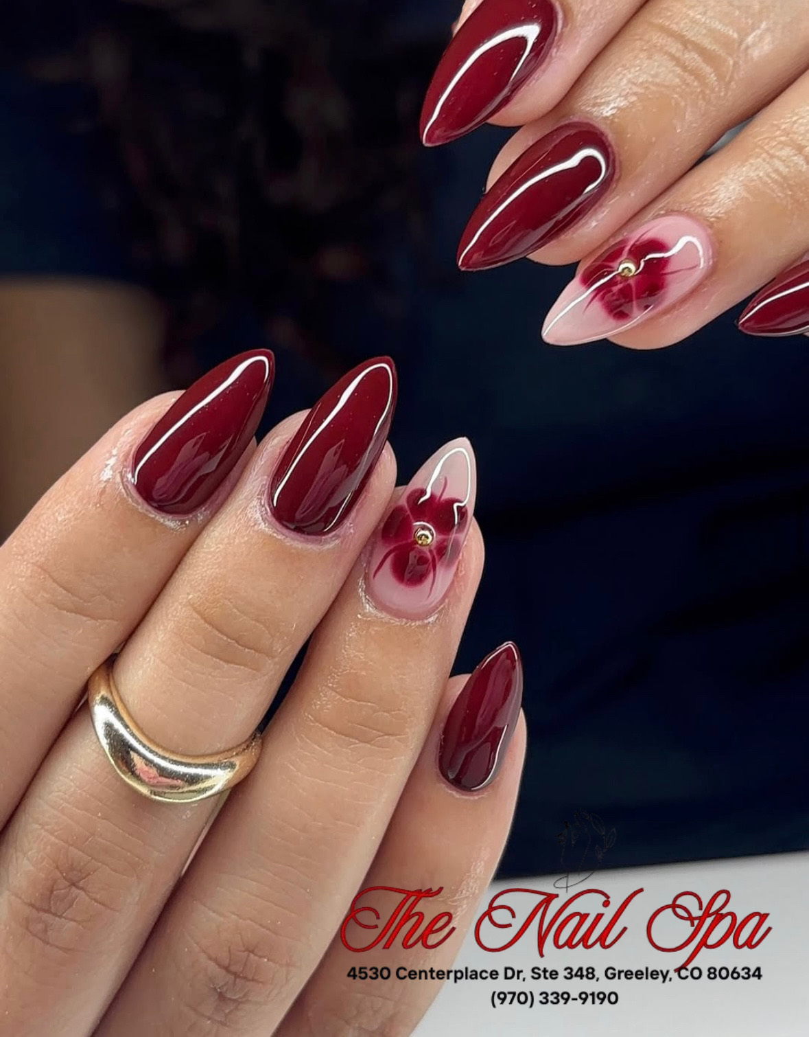 Deep red almond nails with floral art by The Nail Spa of Greeley